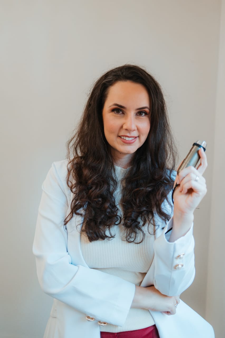 Dra. Vanessa Otavïanï realizando atendimento tricológico com equipamento de tricoscopia para análise do couro cabeludo