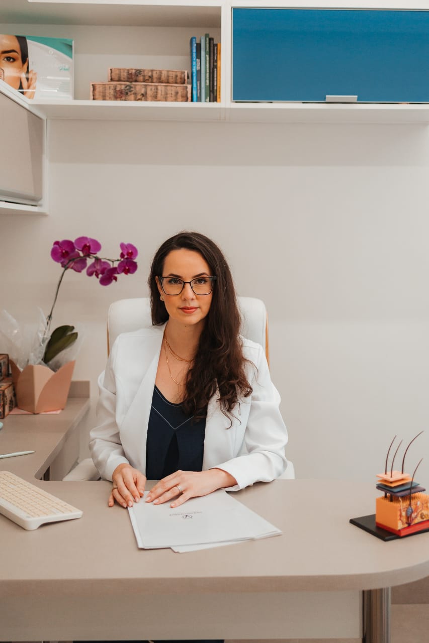 Dra. Vanessa Otavïanï em seu consultório de tricologia realizando diagnóstico por tricoscopia em paciente